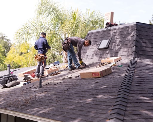 Roofers installing skylights during a reroofing