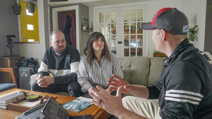 Install explaining Installation Cost vs Benefit to couple in living room