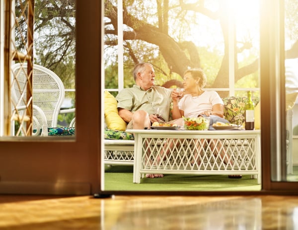 Older couple enjoying drinks on a sunlit porch
