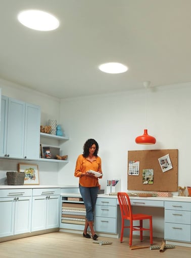 woman standing under sun tunnels which are an eco-friendly home upgrade homeowners may not have considered